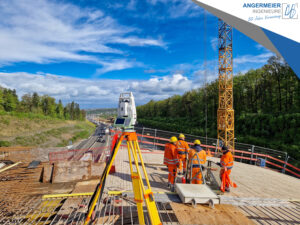 Totalstation Trimble S9 auf der Grünbrücke "Hagenschieß" mit Bauingenieuren im Hintergrund.